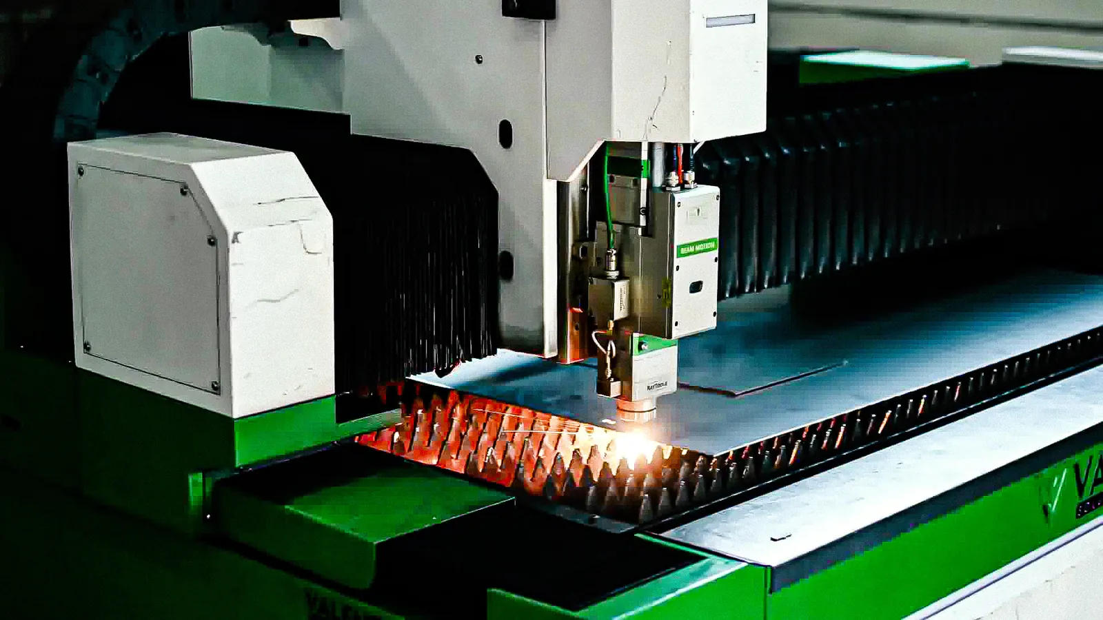 Máquina de corte a laser cortando uma chapa com faíscas, na fábrica da RJ