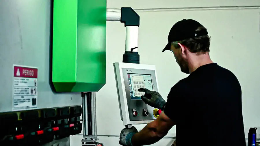 Operador programando o painel da máquina de corte