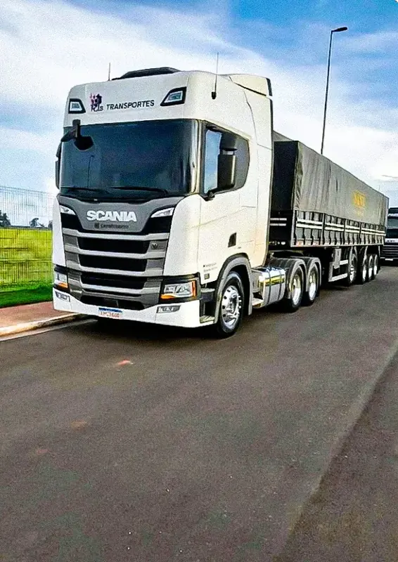 Cavalo mecânico branco com carreta graneleira, na estrada